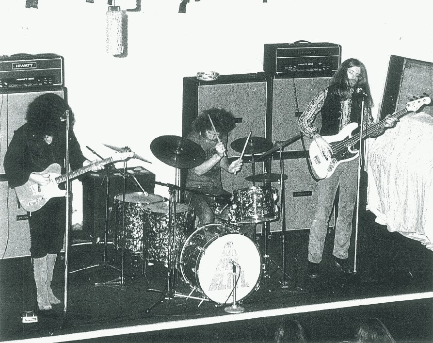 B/w image of three -piece heavy rock band May Bltz on stage